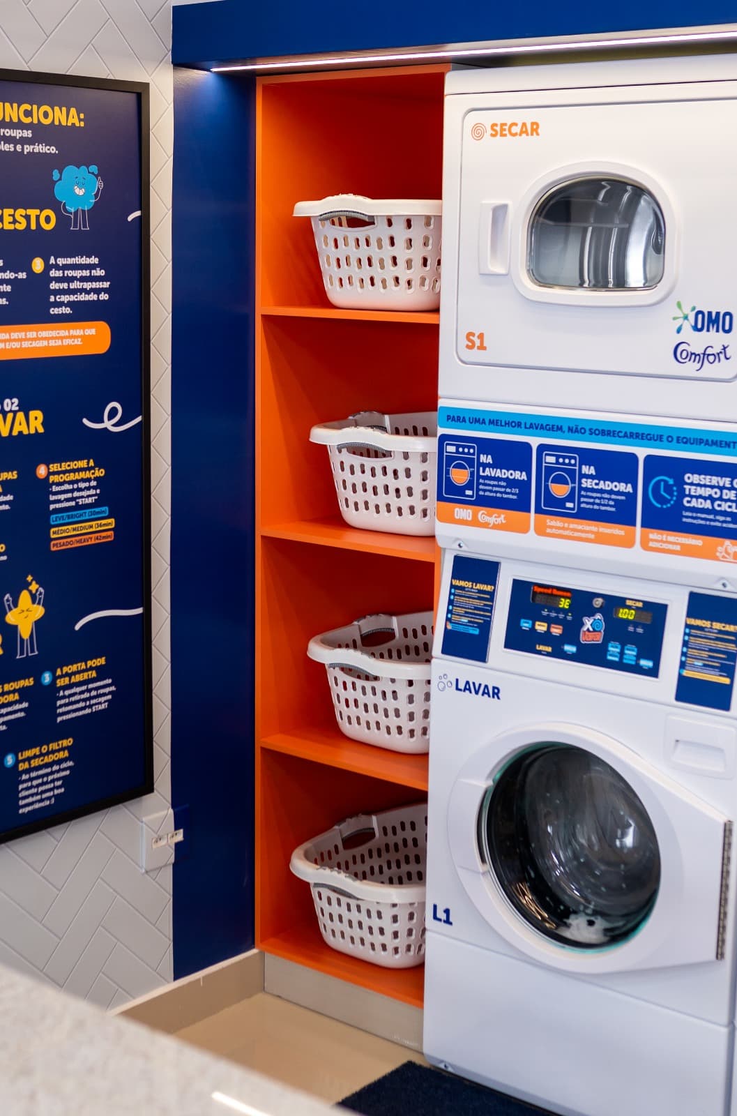 Detalhe das máquinas SpeedQueen e cestas de roupa